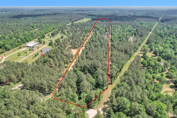 an aerial view of residential houses with outdoor space and trees