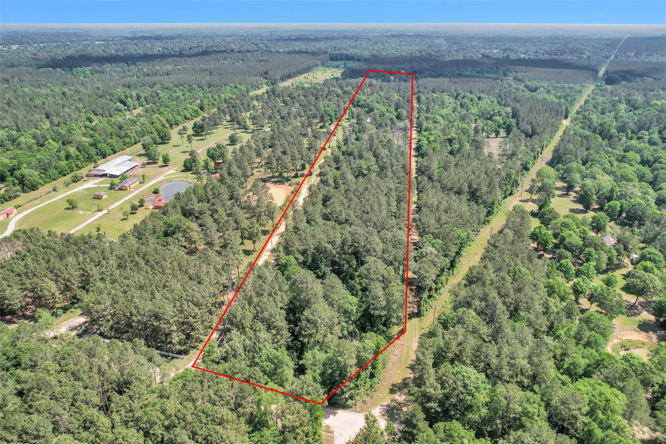 an aerial view of residential houses with outdoor space and trees