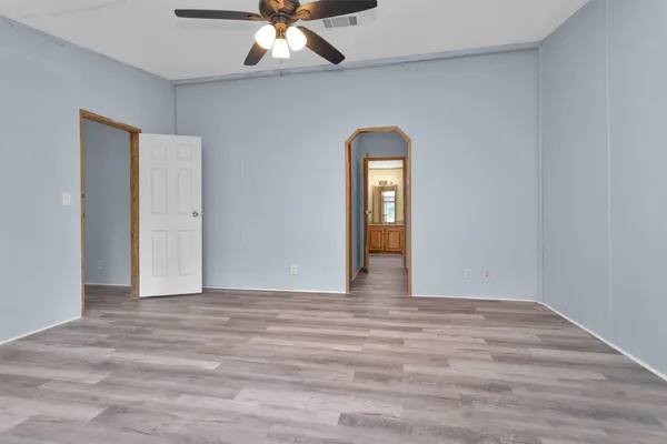 a view of an empty room with a chandelier fan