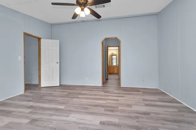 a view of an empty room with a chandelier fan