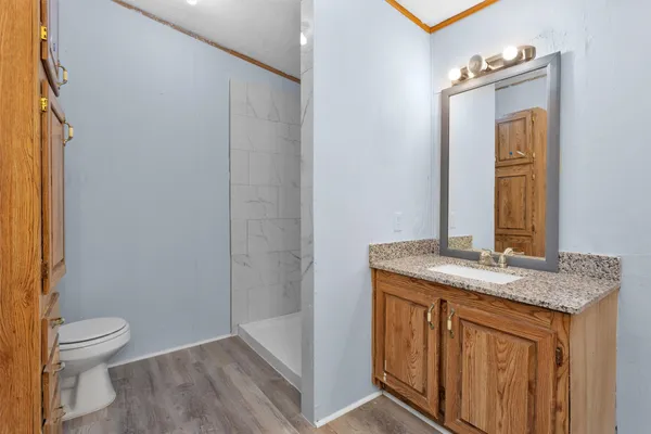 a bathroom with a granite countertop sink toilet and mirror