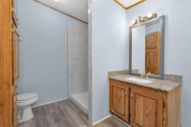 a bathroom with a granite countertop sink toilet and mirror