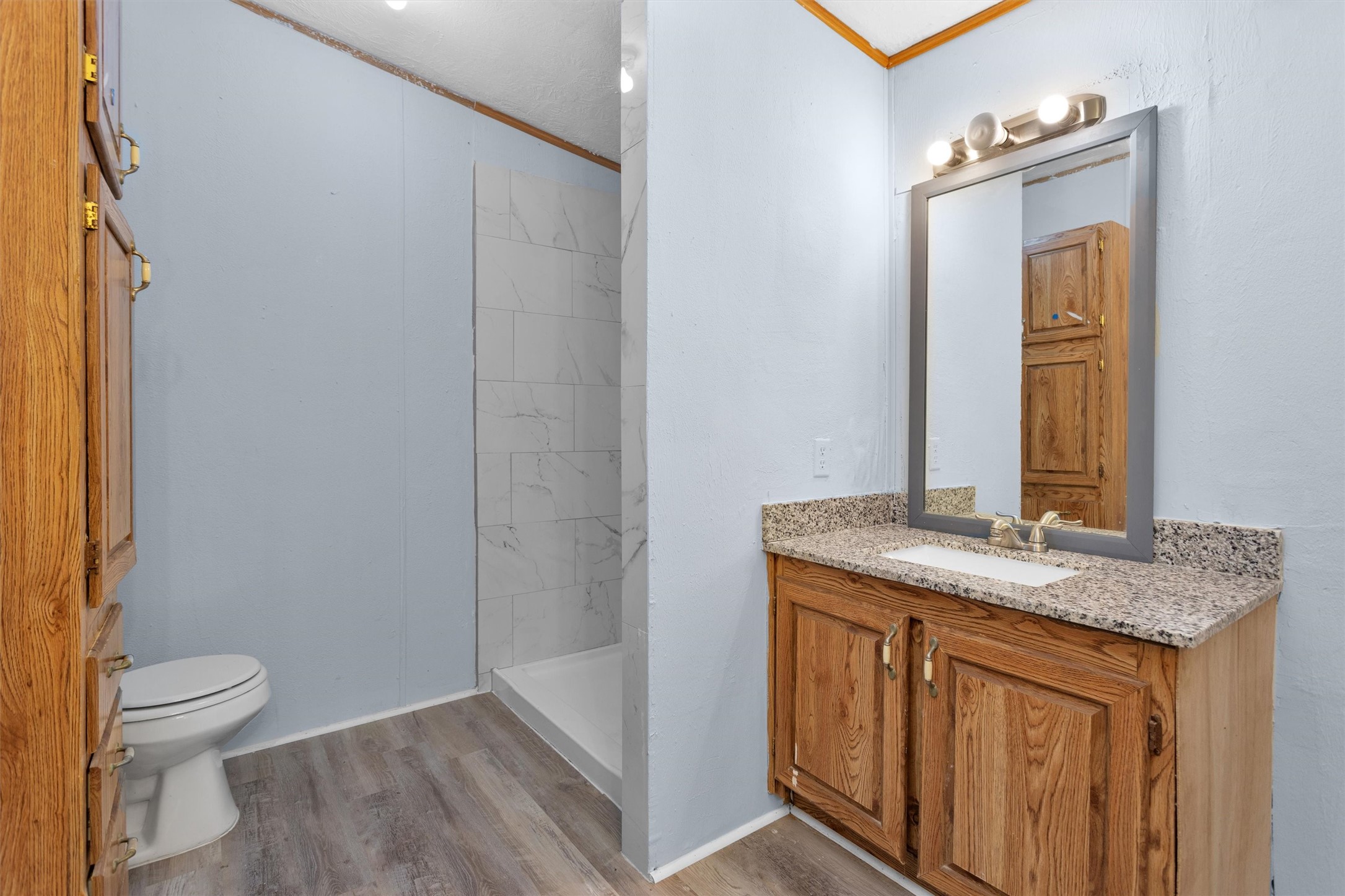 1001 County Line Road Shepherd, TX 77371 - Photo 16 of 46 a bathroom with a granite countertop sink toilet and mirror