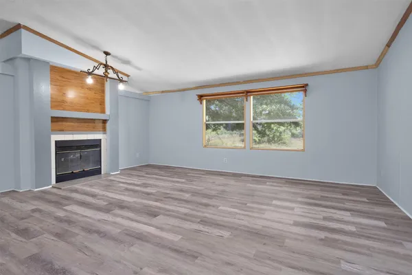 a view of empty room with window and wooden floor