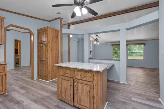 a kitchen with granite countertop a stove and a wooden floors