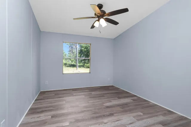 an empty room with a window and a fan