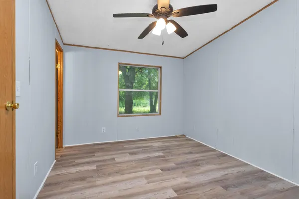 an empty room with window and ceiling fan