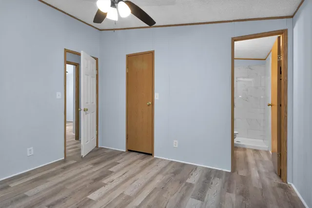 an empty room with wooden floor and closet area