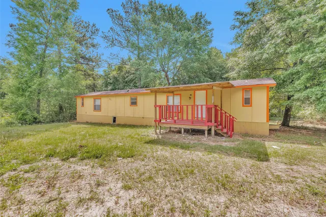 a view of a backyard with a barn and a large tree