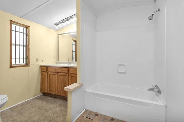 a bathroom with a granite countertop sink a toilet and bathtub