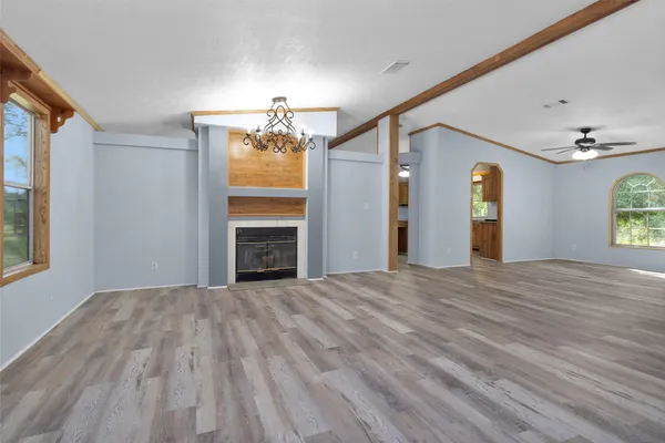 a view of a room with a flat screen tv ceiling fan and window