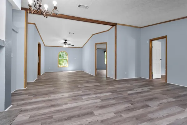 a view of an empty room with window and wooden floor