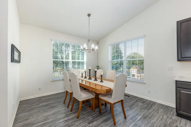 a dining room with furniture a chandelier and wooden floor