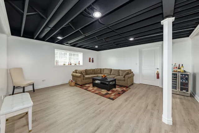 a living room with furniture a wooden floor and next to a window