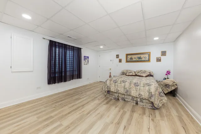 a spacious bedroom with a bed and a dresser