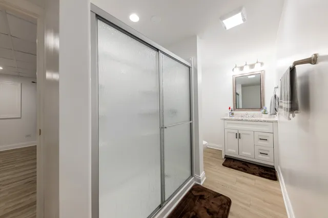 a bathroom with a double vanity sink mirror and shower