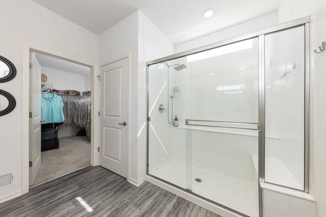 a bathroom with a glass shower door and a glass door