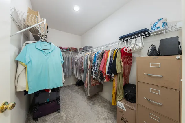 a view of walk in closet with clothes and shoes