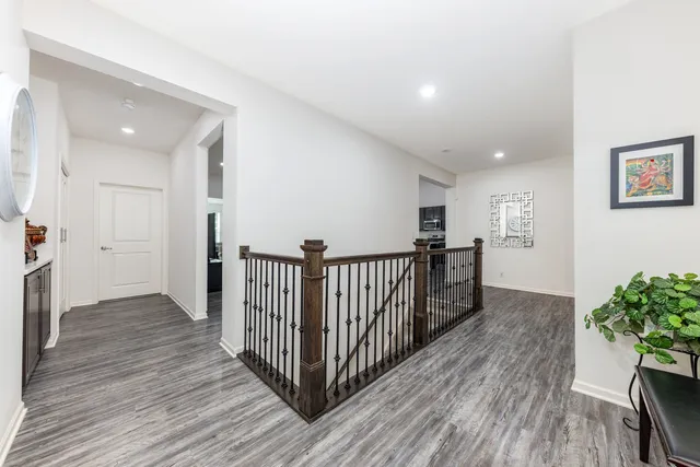 a view of a hallway with wooden floor and stairs