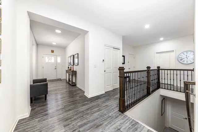 a view of a hallway with wooden floor and stairs