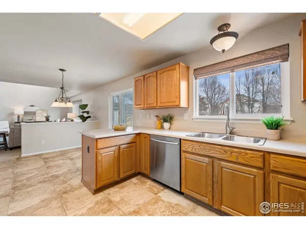 a kitchen with kitchen island granite countertop a sink cabinets and window