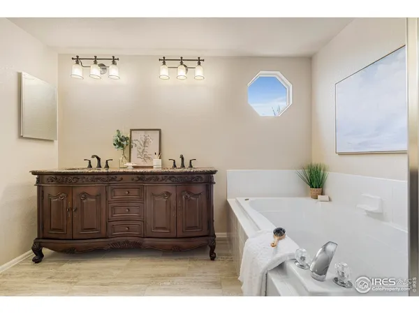 a bathroom with a tub sink and mirror