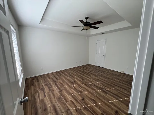 a view of empty room with wooden floor