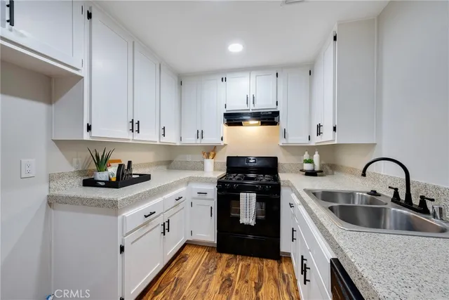 a kitchen with stainless steel appliances granite countertop a sink stove and white cabinets
