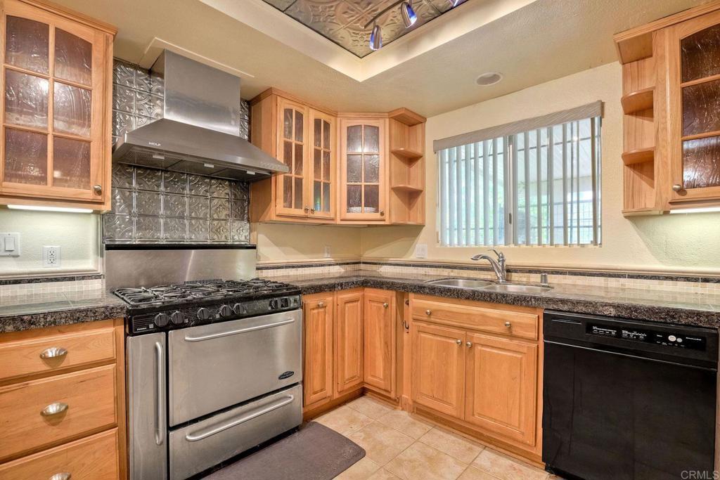 548 Taylor Street Vista, CA 92084 - Photo 20 of 74 a kitchen with granite countertop a stove sink and cabinets