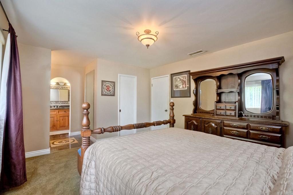 548 Taylor Street Vista, CA 92084 - Photo 31 of 74 a bedroom with a bed and a dresser with mirror
