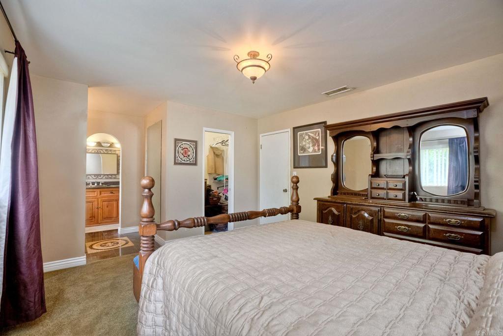 548 Taylor Street Vista, CA 92084 - Photo 32 of 74 a bedroom with a bed and dresser with mirror