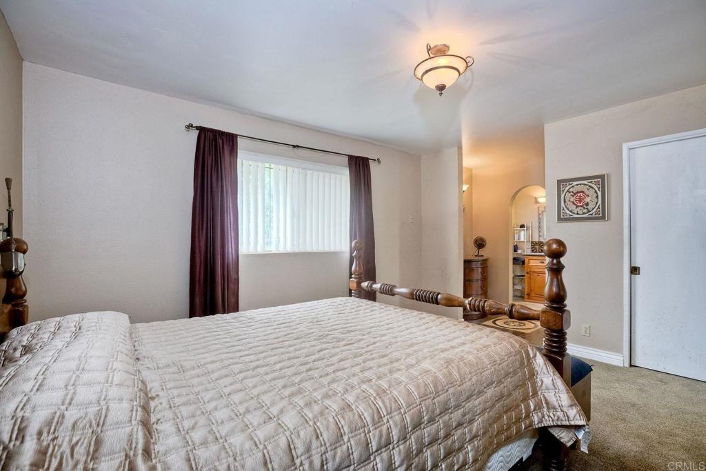 548 Taylor Street Vista, CA 92084 - Photo 33 of 74 a bedroom with a bed and a chandelier