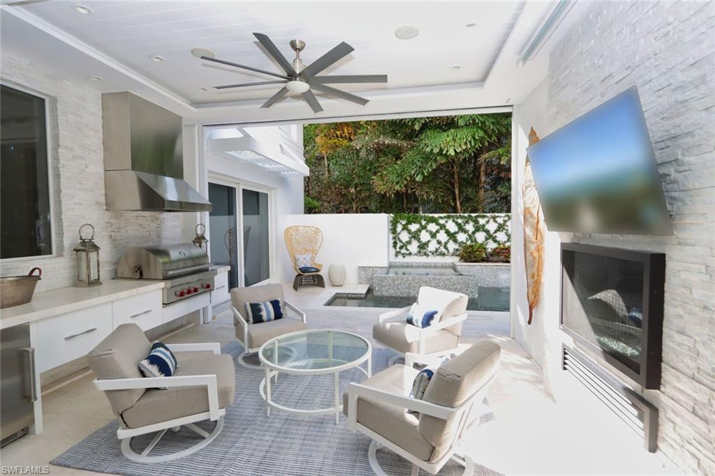 675 2nd Street South Naples, FL 34102 - Photo 40 of 41 a living room with furniture a flat screen tv and a large window