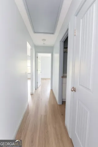 a view of a hallway with wooden floor