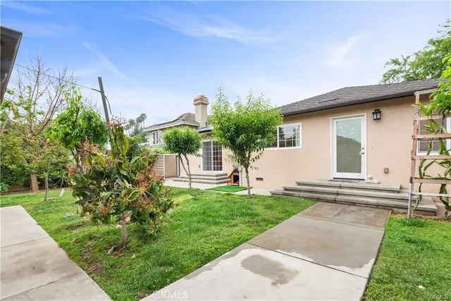 a view of a house with backyard and a tree
