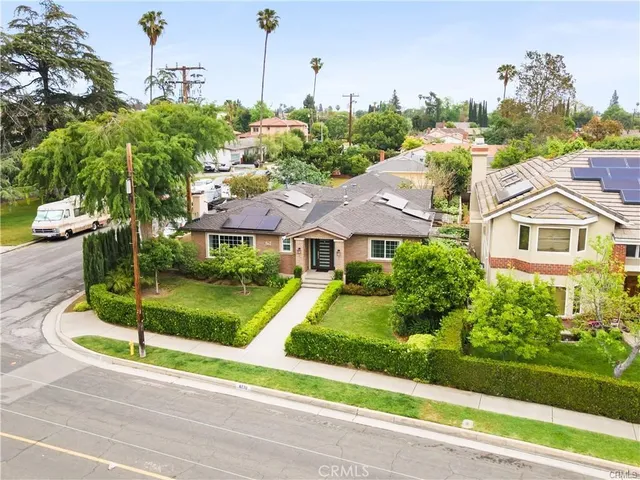 a front view of a house with a yard and potted plants