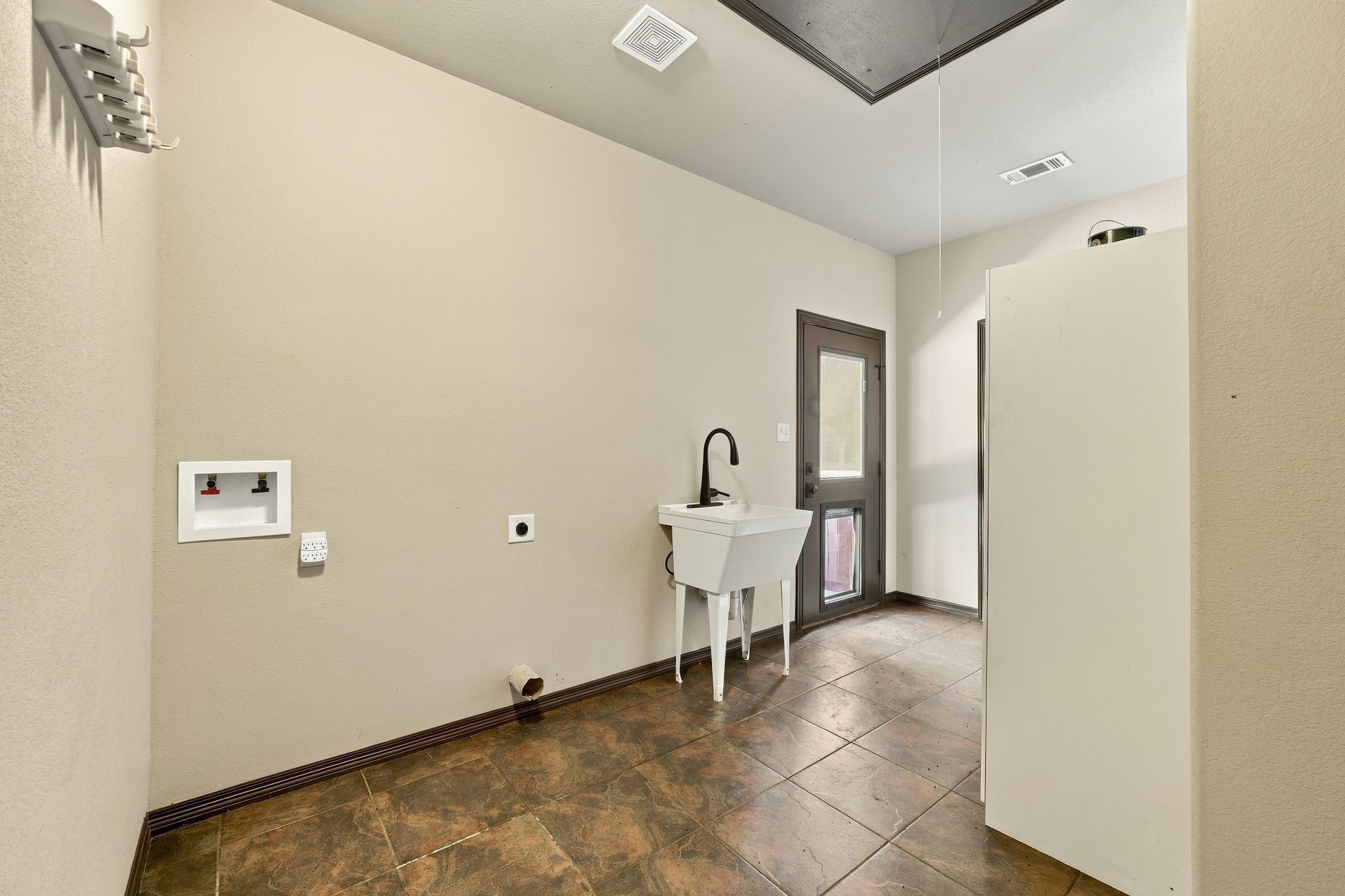 7049 Pine Shadows Road Cleveland, TX 77328 - Photo 23 of 49 Spacious laundry room featuring a utility sink, washer/dryer hookups, and convenient outdoor access.