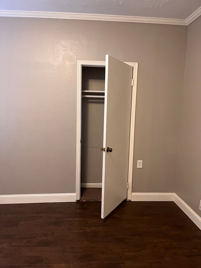 1212 18th Street, Unit A Columbus, GA 31901 - Photo 7 of 19 a view of an empty room with wooden floor and closet