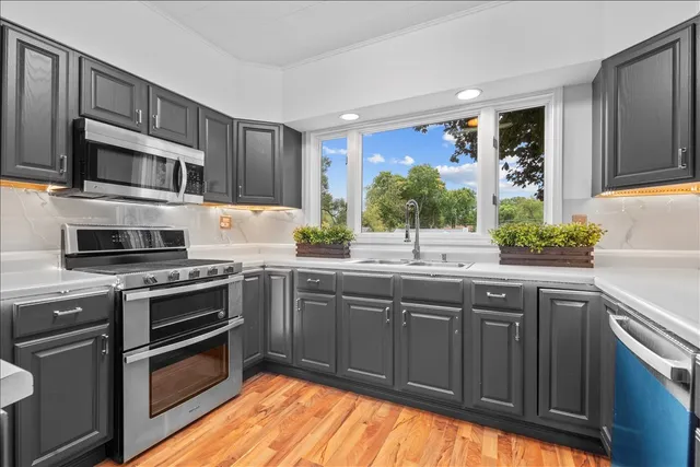 a kitchen with stainless steel appliances granite countertop a stove microwave and sink