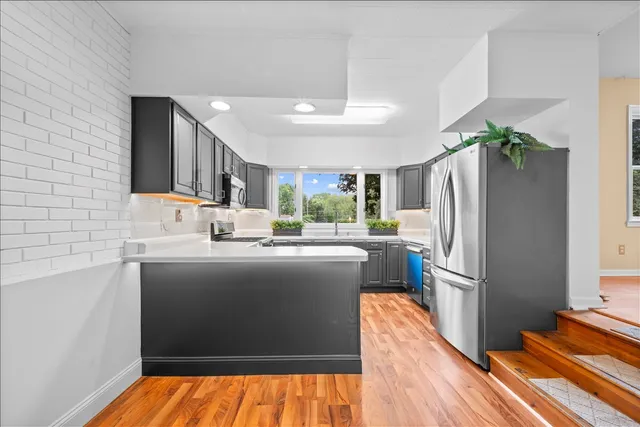 a kitchen with kitchen island a counter top space a sink and refrigerator