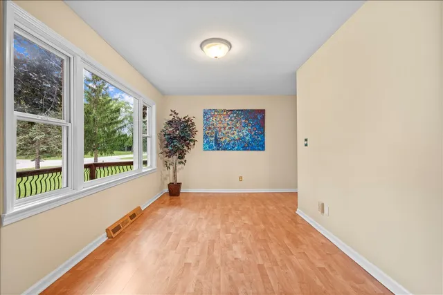 a view of a big room with wooden floor and windows