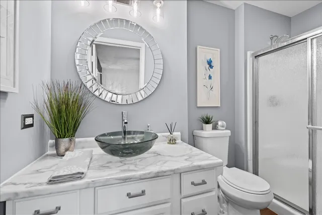 a bathroom with a granite countertop sink a toilet and a mirror