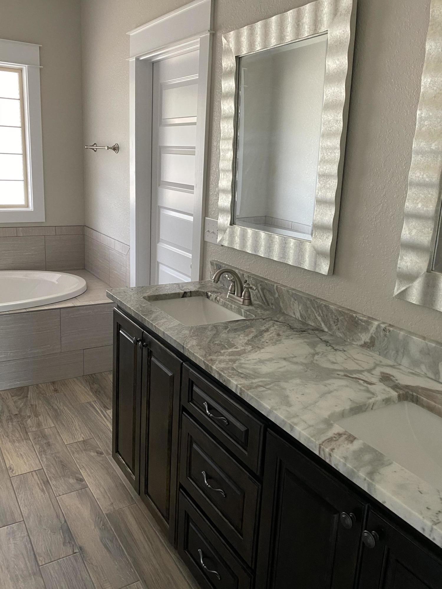 3958 Painter Branch Road Crestview, FL 32539 - Photo 11 of 15 a bathroom with a granite countertop sink a mirror and a bathtub