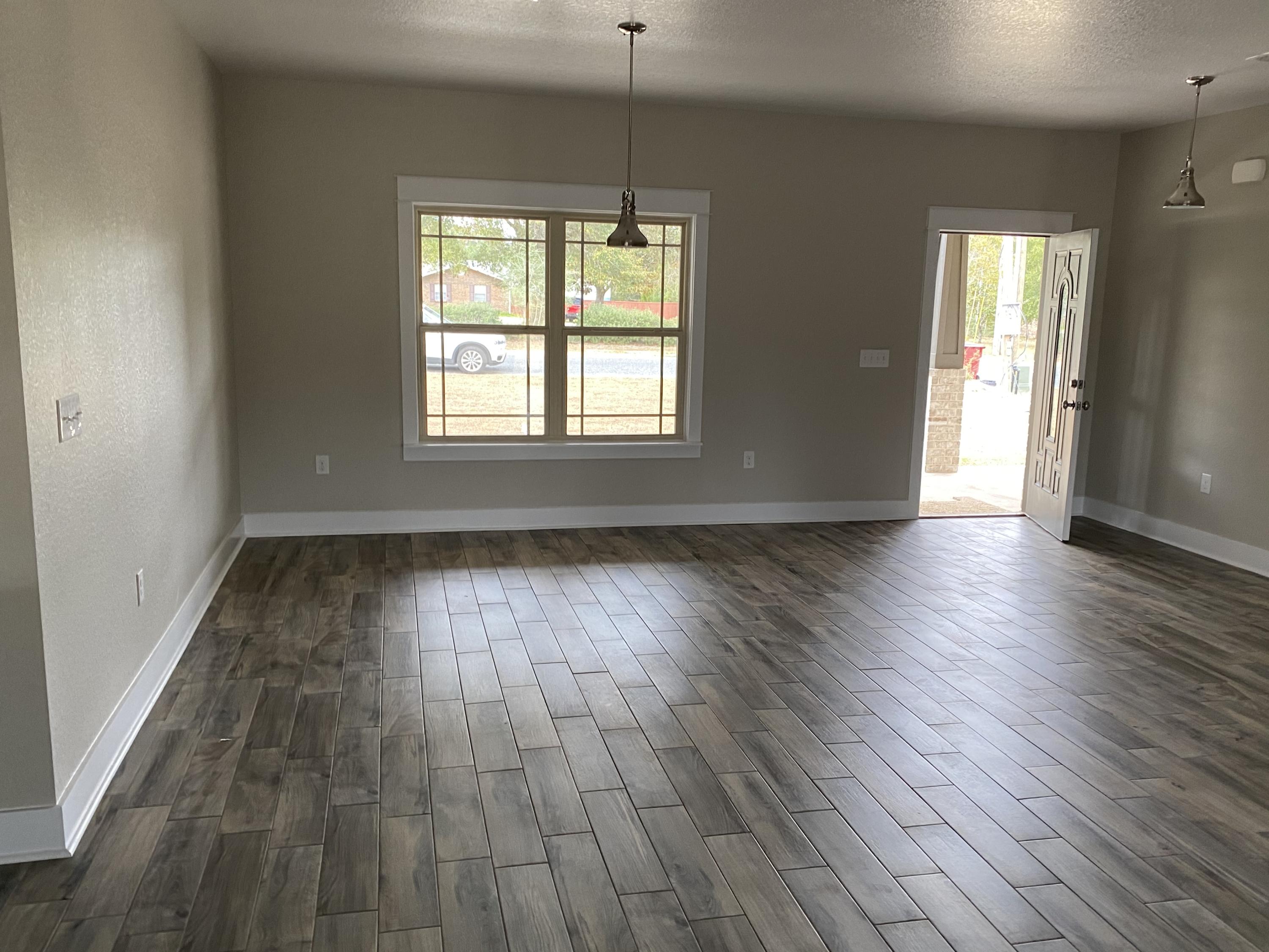 3958 Painter Branch Road Crestview, FL 32539 - Photo 9 of 15 an empty room with wooden floor and windows