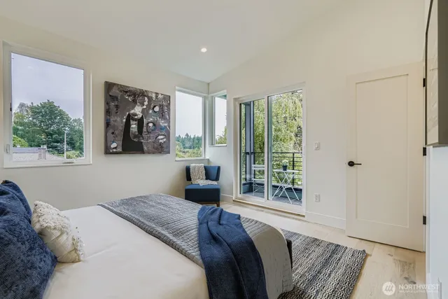 a bedroom with a bed and a large window with outer view