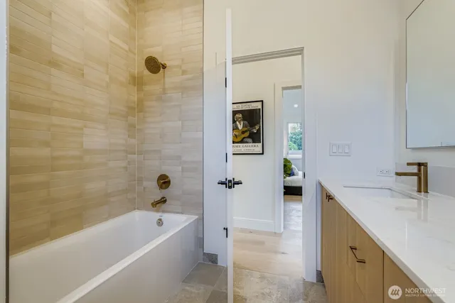 a bathroom with a tub sink and mirror