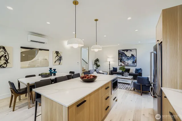 a view of a dining room and livingroom with furniture wooden floor a rug a flat screen tv a painting and a chandelier