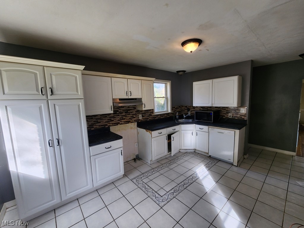 3602 Silsby Road University Heights, OH 44118 - Photo 2 of 19 Kitchen featuring tasteful backsplash, stainless steel microwave, white cabinets, light tile flooring, and dishwasher