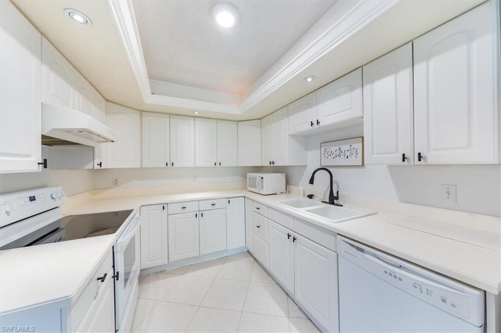 925 Palm View Drive, Unit E118 Naples, FL 34110 - Photo 12 of 26 a kitchen with white cabinets appliances and sink