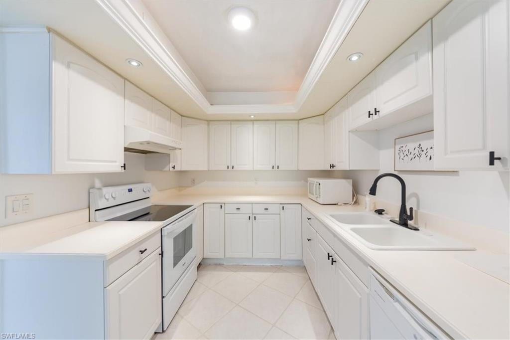 925 Palm View Drive, Unit E118 Naples, FL 34110 - Photo 13 of 26 a kitchen with cabinets appliances a sink and a counter top space